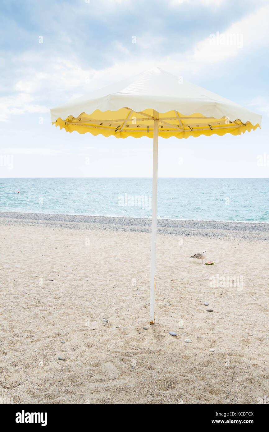 Parapluie jaune sur la plage d'été Banque D'Images