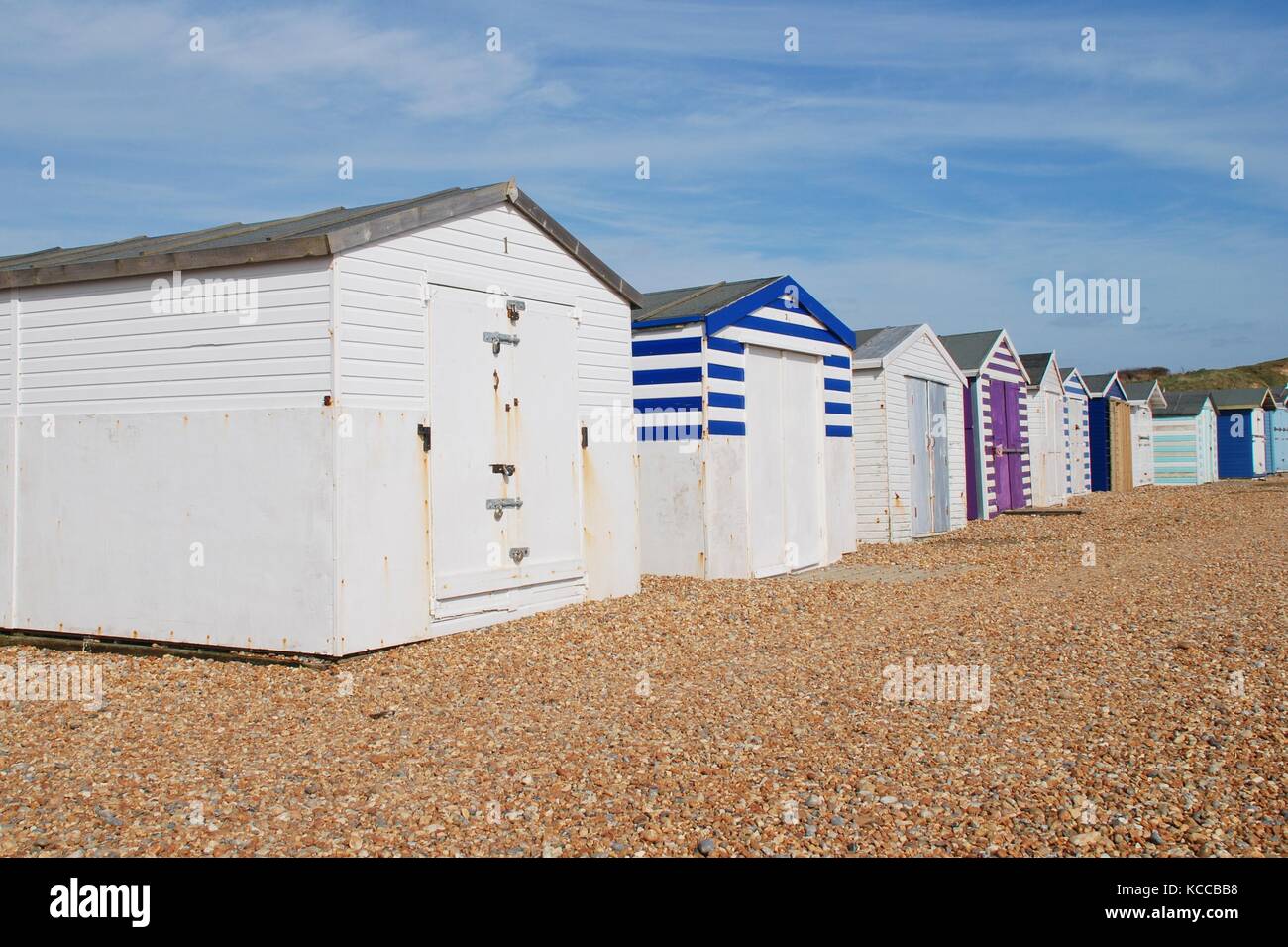 Une rangée de cabines de plage traditionnel sur la plage de galets à glyne gap entre Hastings et Bexhill-on-sea dans l'East Sussex, Angleterre le 10 mars 2015. Banque D'Images