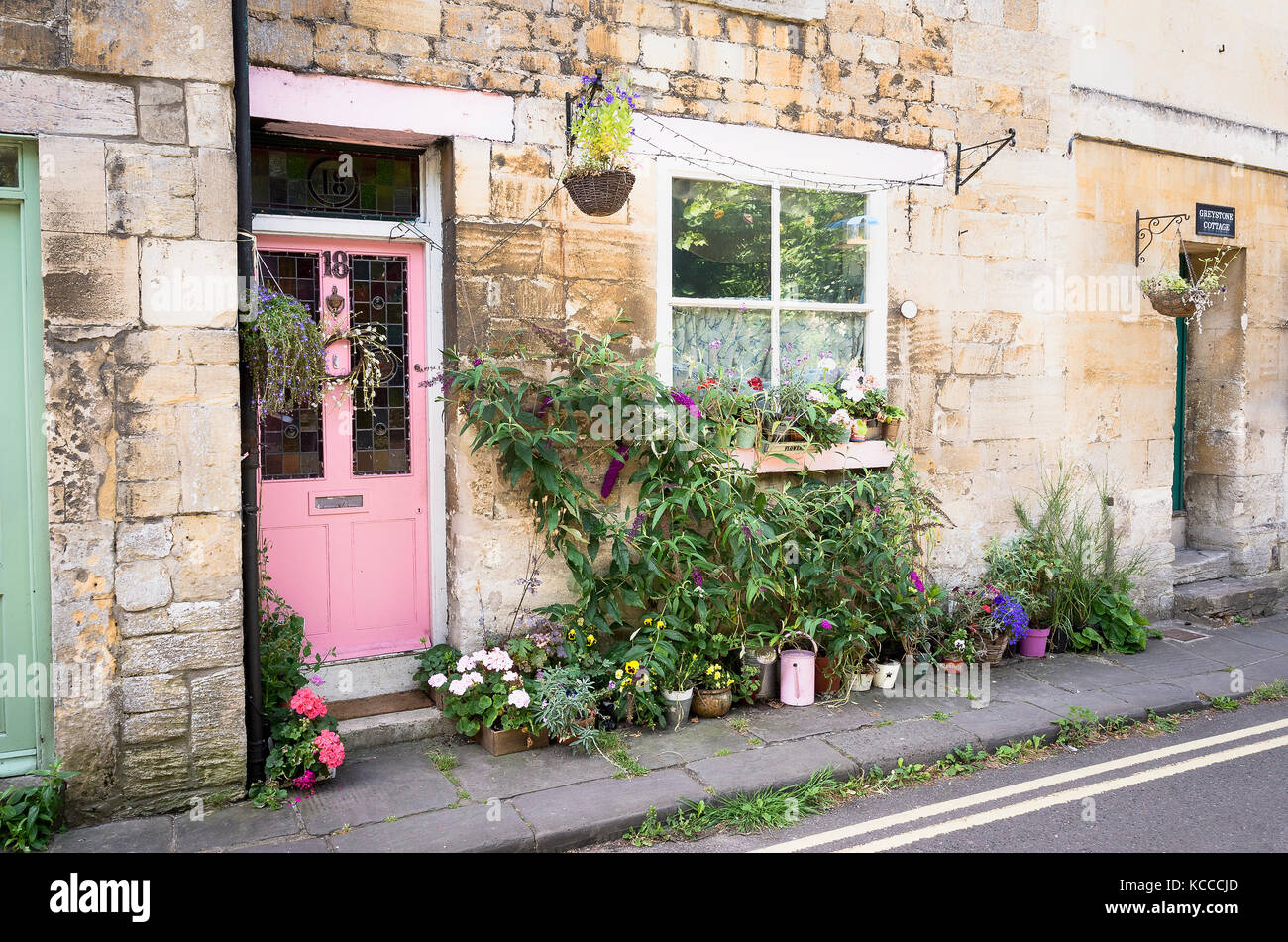 Une porte rose et un jardin à l'avant en pot pour une ville cottage dans le centre de Bradford on Avon Wiltshire England UK Banque D'Images