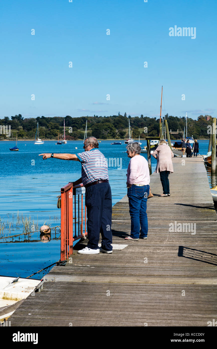 Couple de personnes âgées et et une femme debout sur le club de voile à la broche jetée Mill et de rechercher la rivière Orwell, Chelmondiston, Essex, UK Banque D'Images