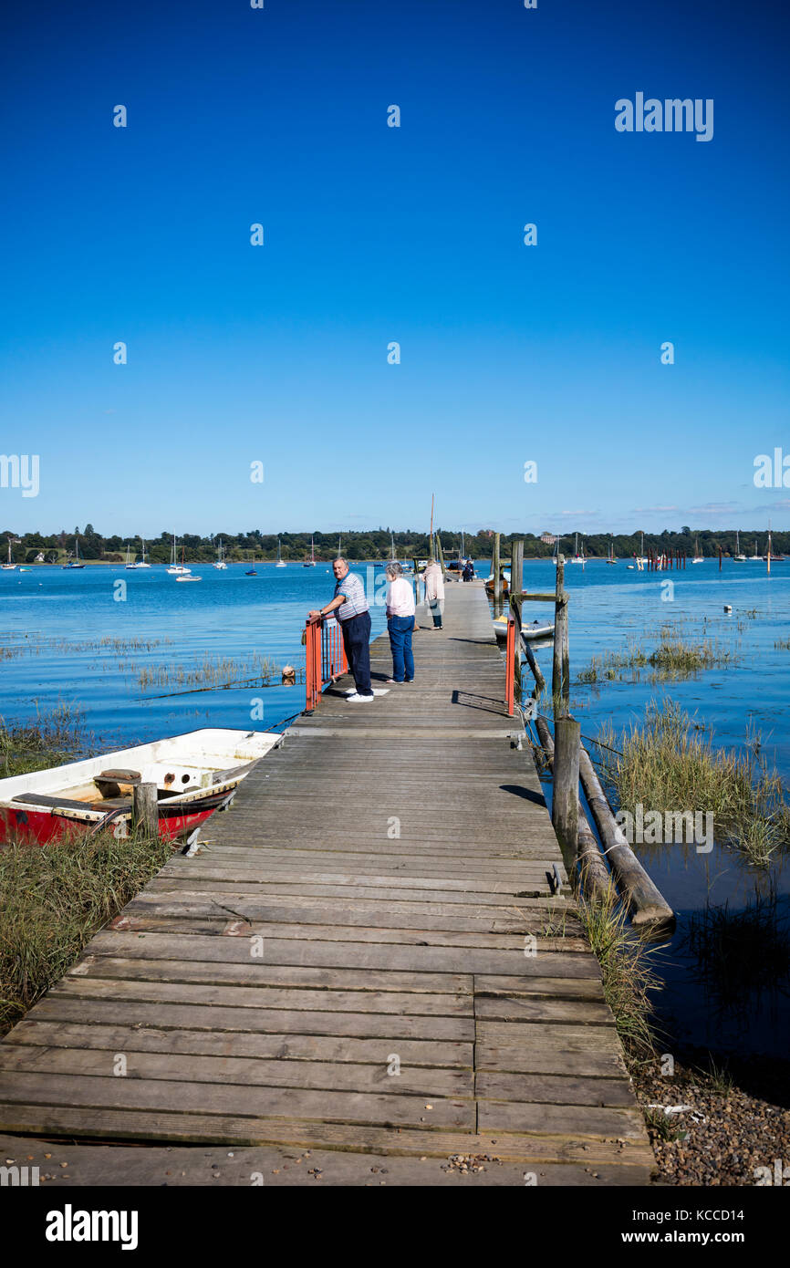 Couple de personnes âgées et et une femme debout sur le club de voile à la broche jetée Mill et de rechercher la rivière Orwell, Chelmondiston, Essex, UK Banque D'Images
