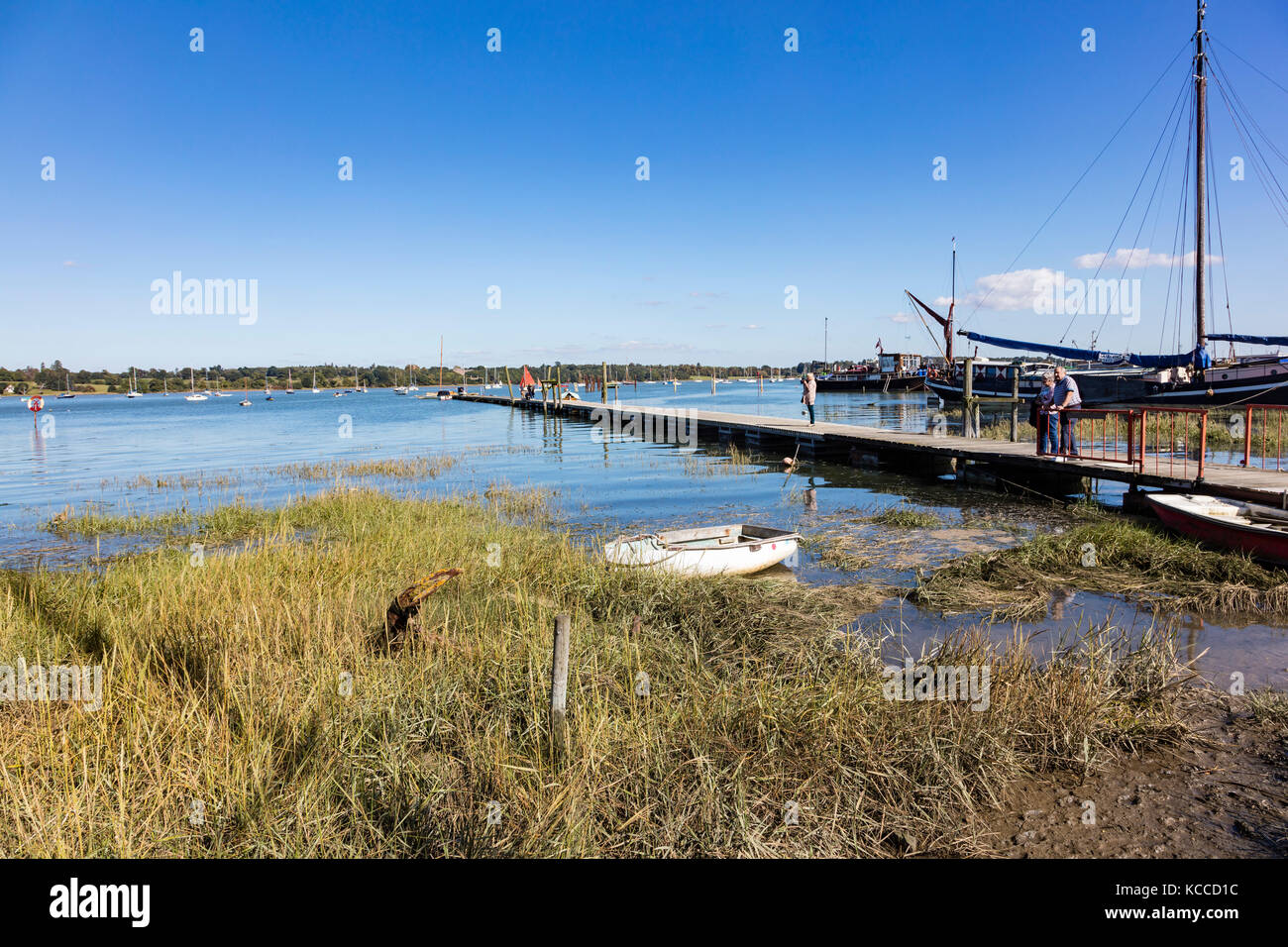 Couple de personnes âgées et et une femme debout sur le club de voile à la broche jetée Mill et de rechercher la rivière Orwell, Chelmondiston, Essex, UK Banque D'Images