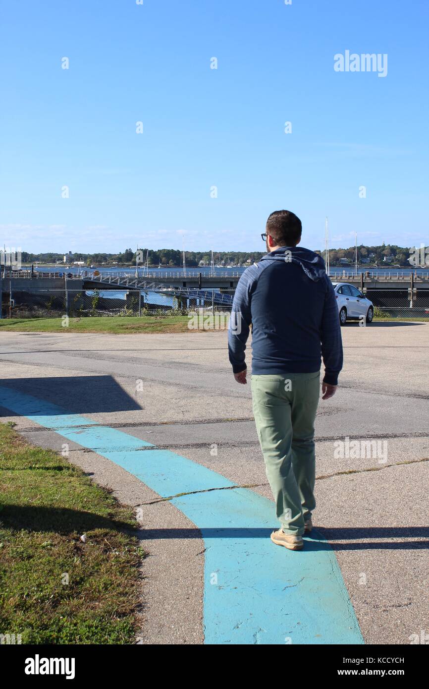 Un homme marche sur un chemin qui est bordée de bleu dans la région de l'Atlantique Nord dans le New Hampshire Banque D'Images