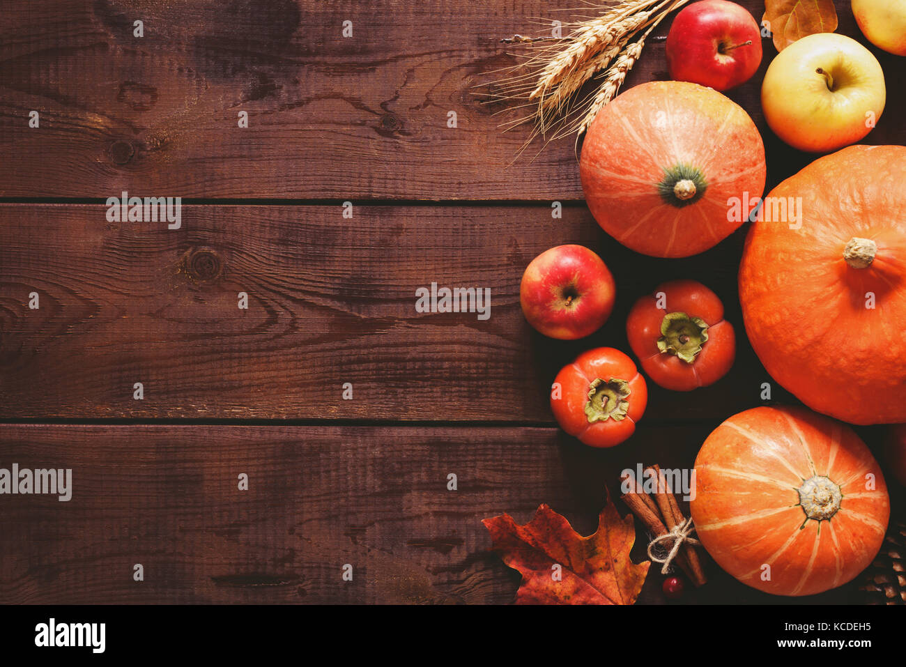 Contexte : thanksgiving citrouilles, pommes, blé, feuilles d'érable, les cônes et les épices sur fond de bois brun automne saison. arrière-plan pour Thanksgiving Banque D'Images