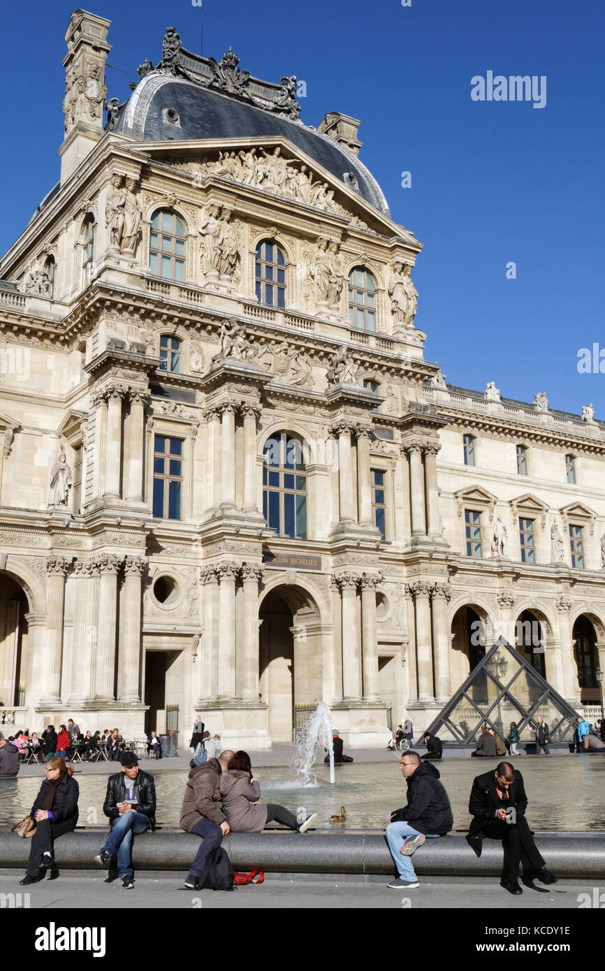 PARIS, FRANCE, le 12 mars 2015 : les gens se reposent dans la cour du Palais du Louvre.Le Louvre est un ancien palais royal situé sur la rive droite de la Seine à pari Banque D'Images