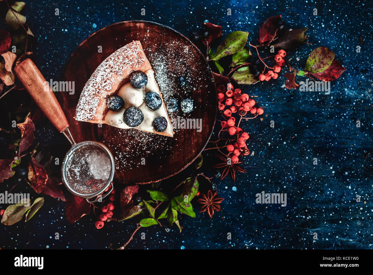 Close-up d'un morceau de tarte à la citrouille avec du sucre en poudre et d'une crépine sur une des plaques en bois faits à la main à l'automne. plats télévision lay. aliments stylisé conceptuel still life, table top shot sur fond sombre. Banque D'Images