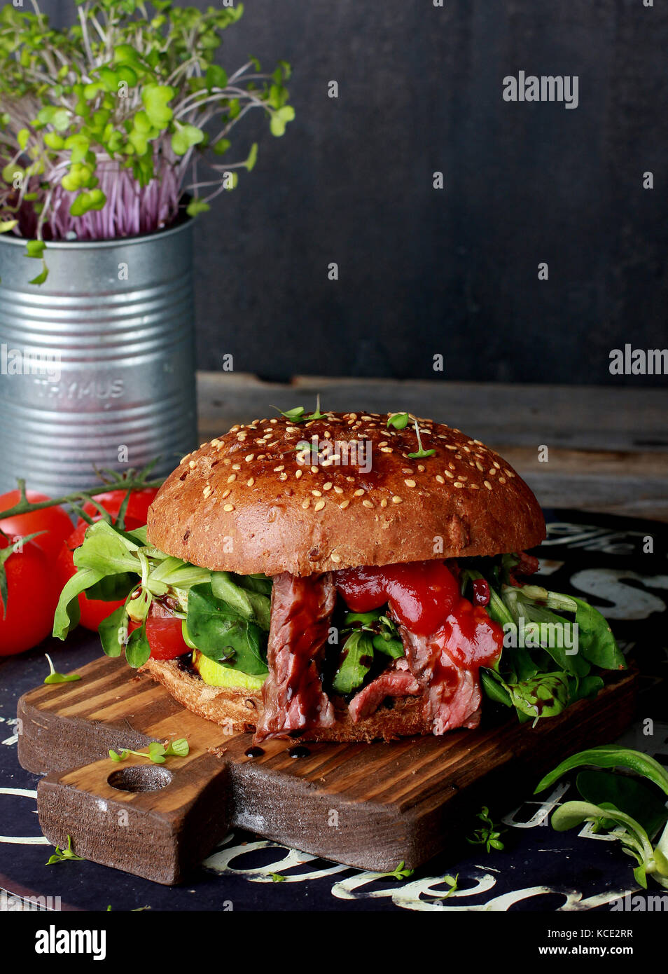 Big burger de viande juteuse sur planche de bois Banque D'Images