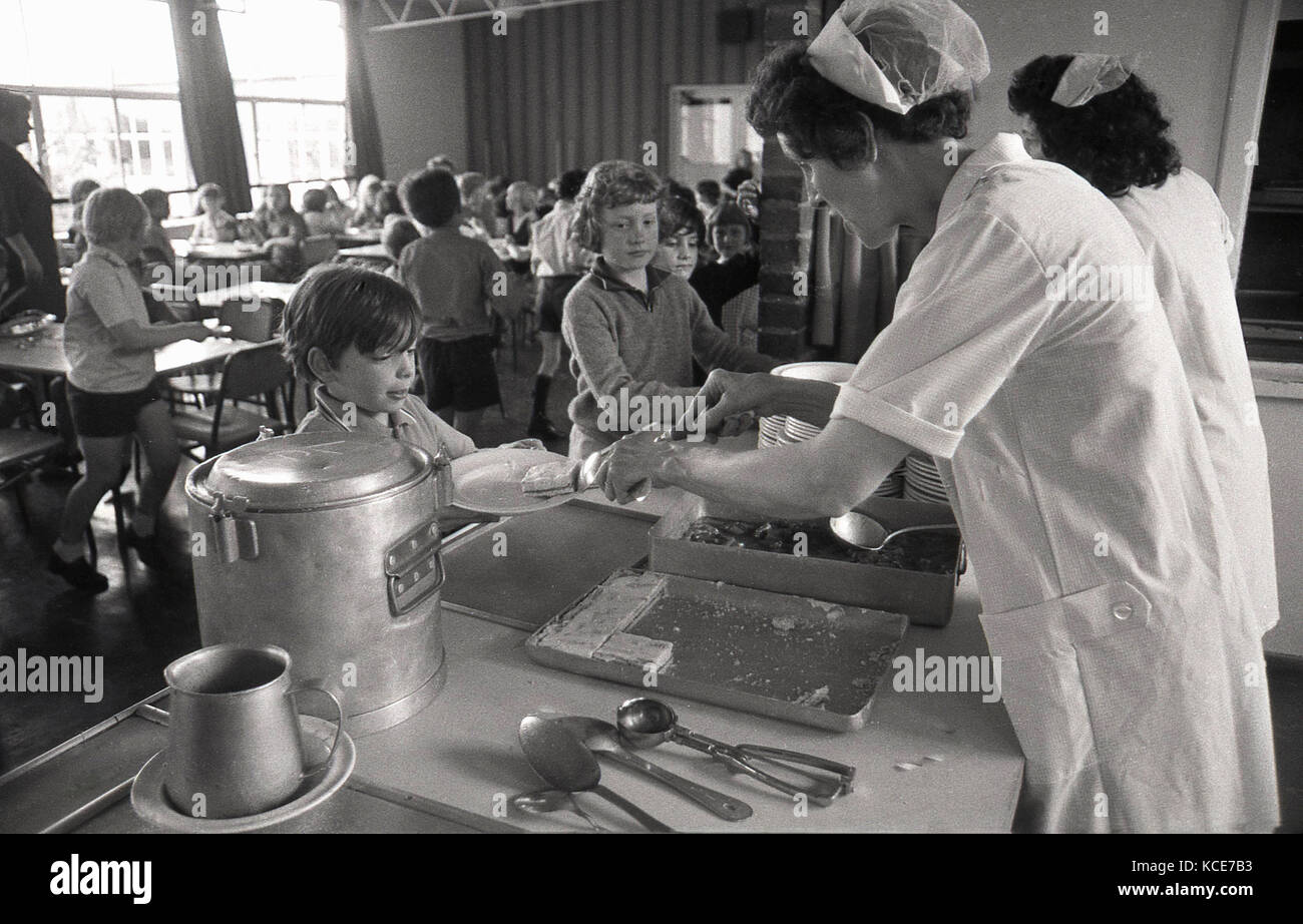 Années 1970, historique, déjeuner scolaire mesdames servant de la nourriture aux enfants à l'heure du déjeuner, le Langbourne l'école primaire, 76200, London, SE21, England, UK. Banque D'Images
