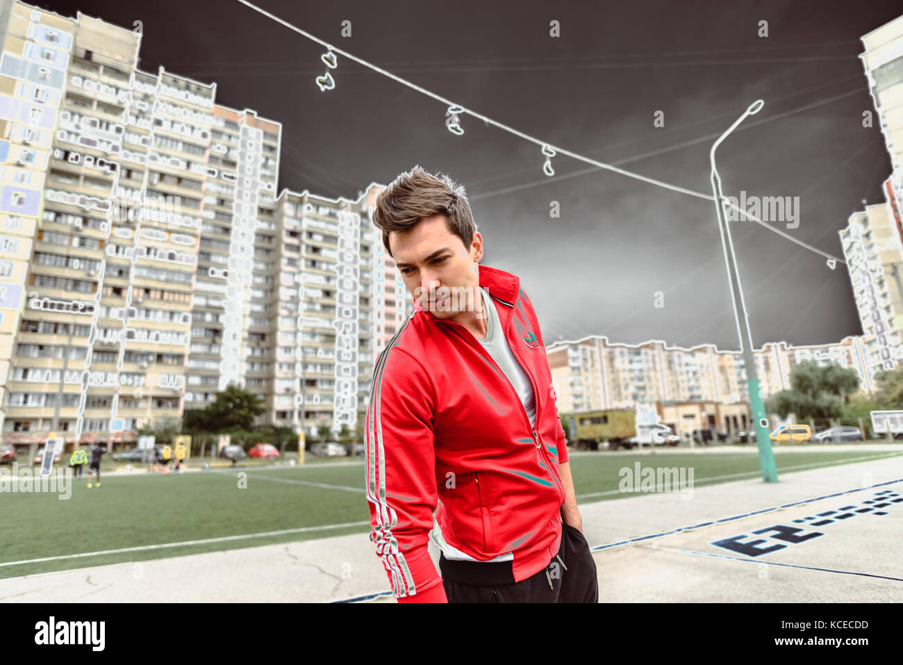 Jeune homme dans un costume sport rouge sur fond d'une ville Banque D'Images