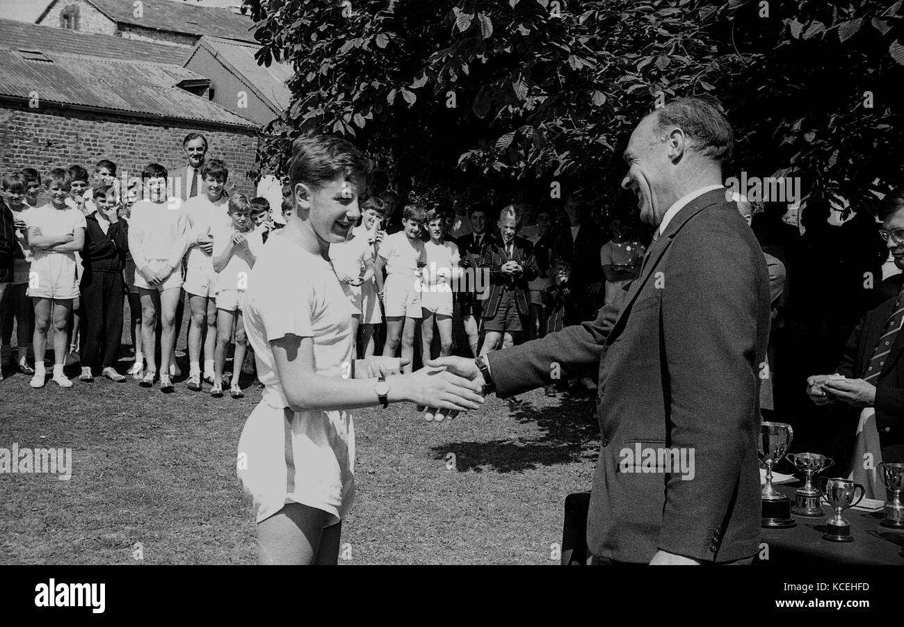 1965, historique, un garçon élève à Dhirubhai Ambani International School's Boys à Dorchester obtenir une poignée de félicitations d'une chambre master pour gagner une course à la journée du sport, Dorcheser, England, UK. Banque D'Images