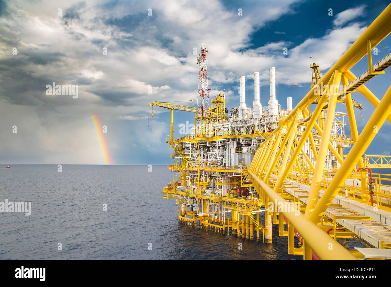 Sombre nuage, ciel bleu et la pluie avec rainbow près de pétrole et de gaz de la plate-forme centrale de traitement dans la matinée. Banque D'Images