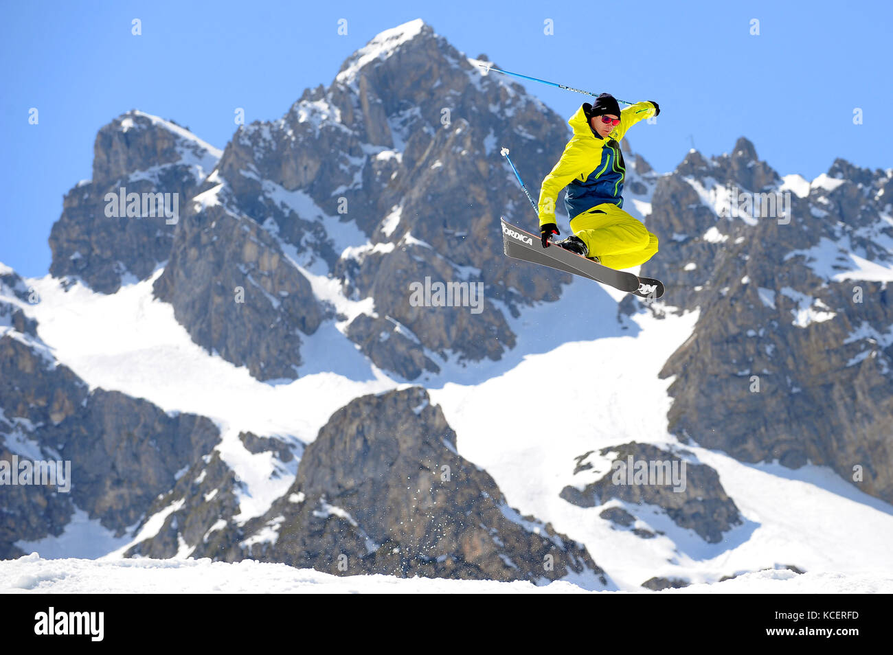 Un homme passe en skis dans la station alpine de Courchevel, avec le sommet de la Saulire en arrière-plan. Banque D'Images