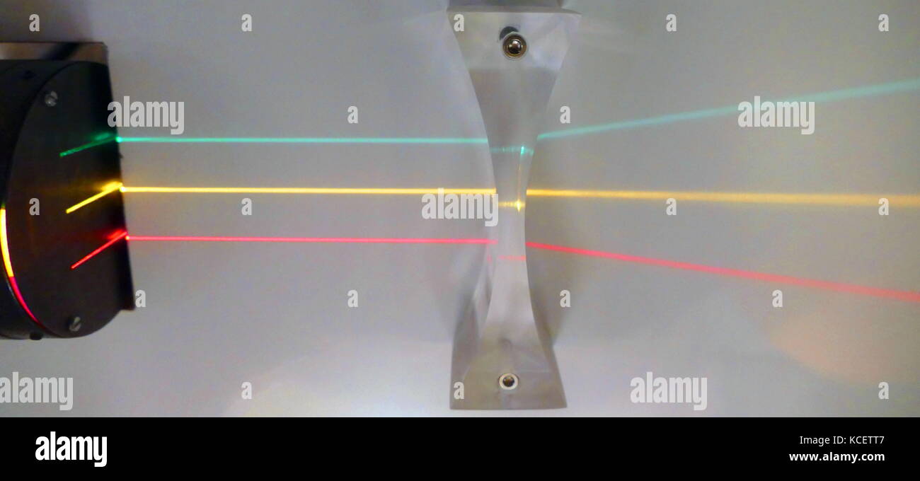 Trois faisceaux parallèles de la lumière sont perçus à travers une lentille concave. Une lentille concave est plus mince au centre que sur les bords. Les rayons de lumière qui passent à travers les lentilles sont distribués (elles divergent). Une lentille concave est une lentille divergente. Banque D'Images