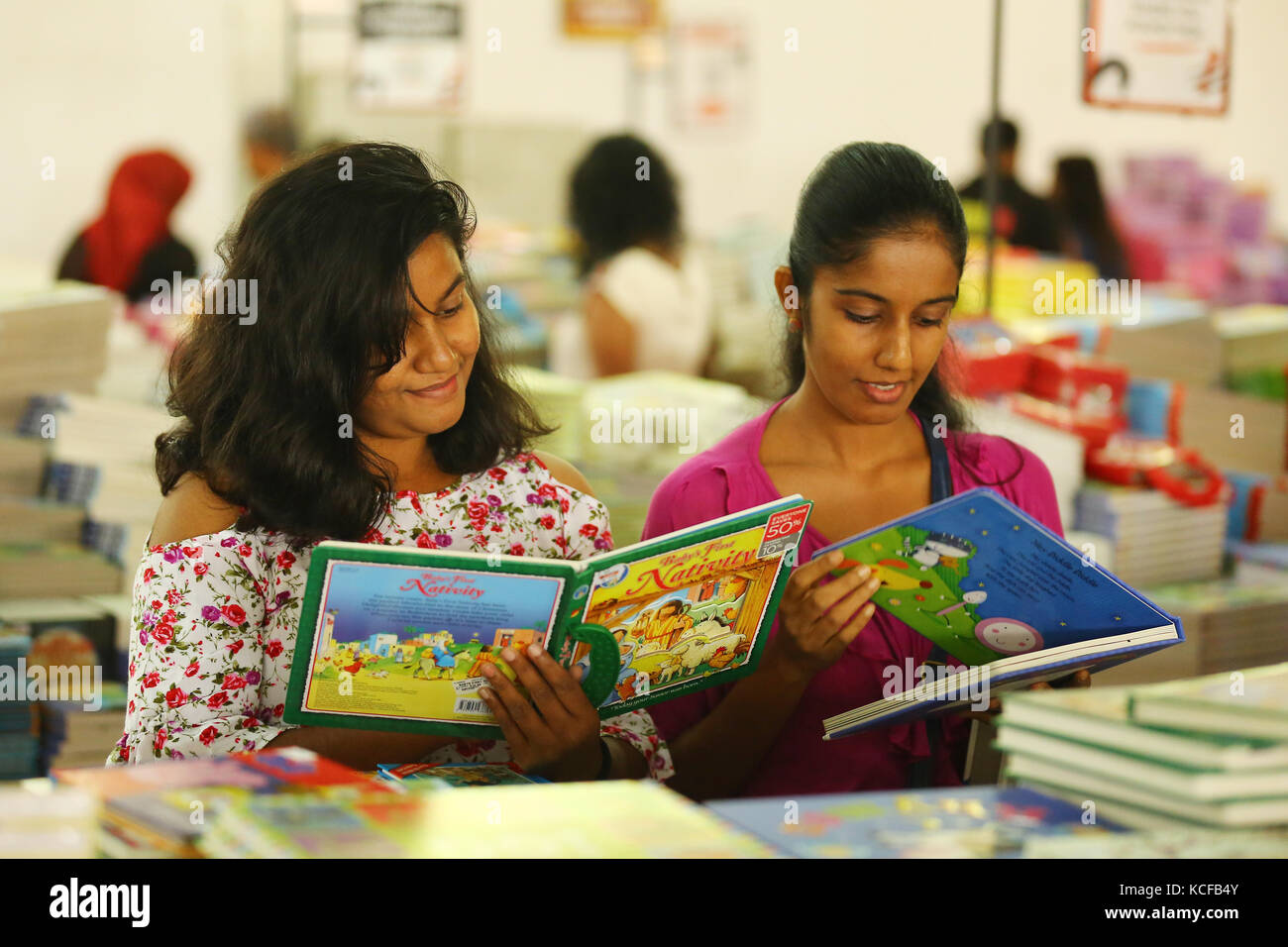 Deux dames lire le livre pendant le grand loup vente de livres à Colombo, Sri Lanka. Banque D'Images
