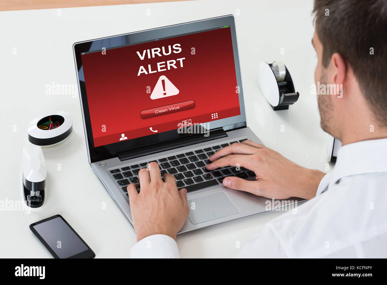 Close-up of young businessman using laptop avec écran d'alerte au virus sur plus de 24 Banque D'Images