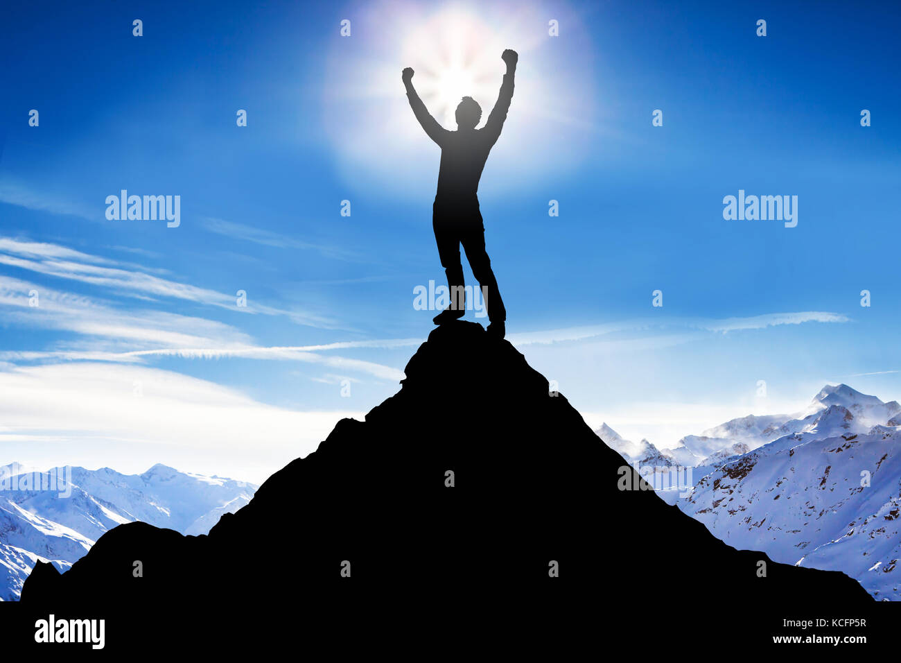 Silhouette d'un homme après avoir réussi l'escalade contre les montagnes enneigées Banque D'Images