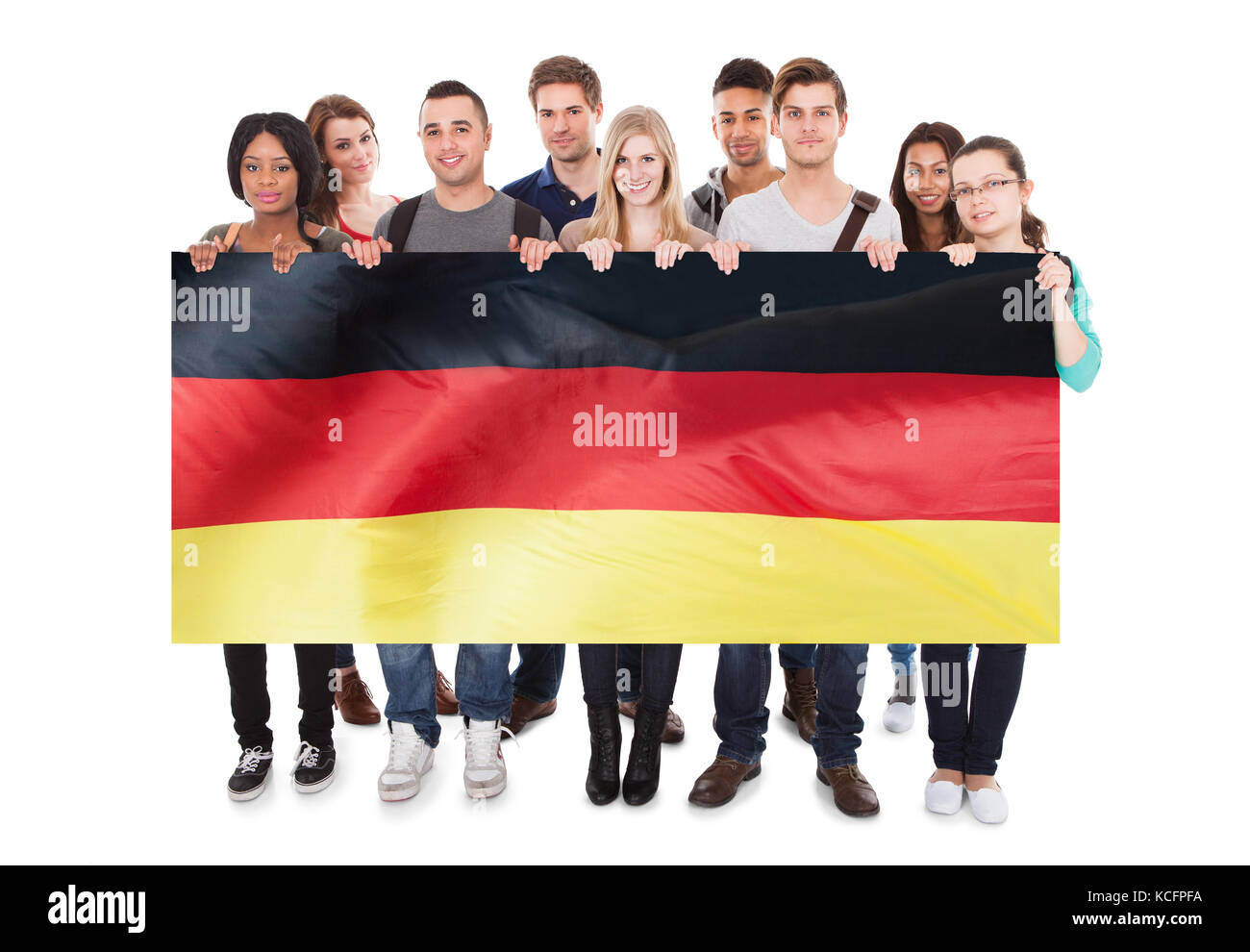 Groupe de jeunes gens tenant drapeau allemand contre fond blanc Banque D'Images
