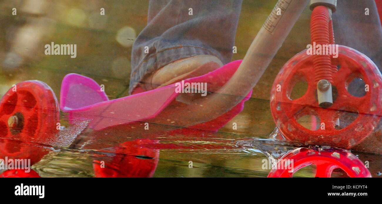 Scooter jouet dans une palette de réflexion de l'eau pendant l'hiver Banque D'Images