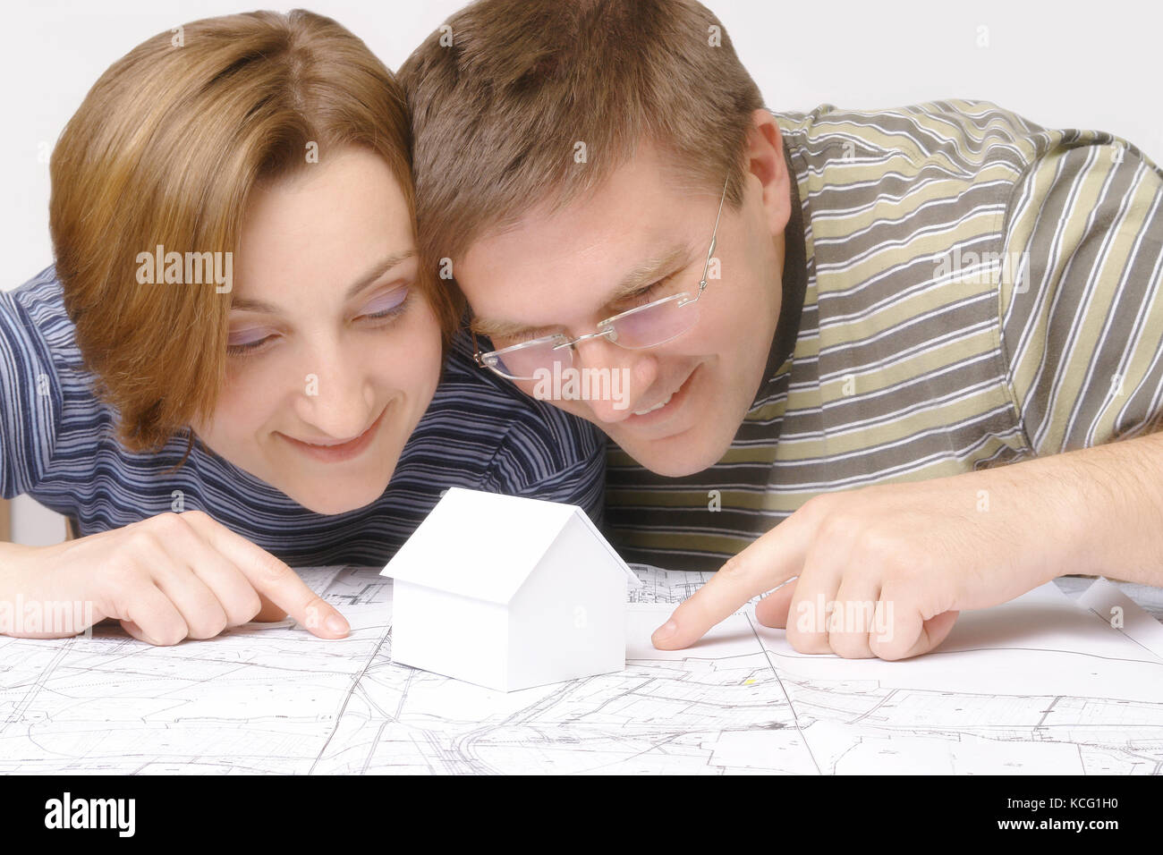 Les jeunes couples à la recherche de près plan de bâtiment avec peu de blanc modèle maison en carton Banque D'Images