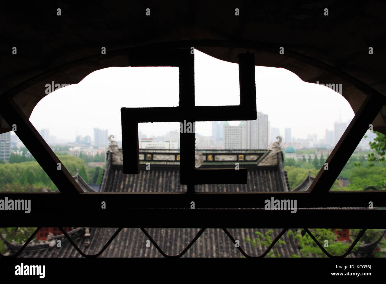 Un bâtiment et vue sur la ville derrière la croix gammée signe. à Nanjing Temple. 16, avril, 2009. Nanjing, Jiangsu, Chine Banque D'Images