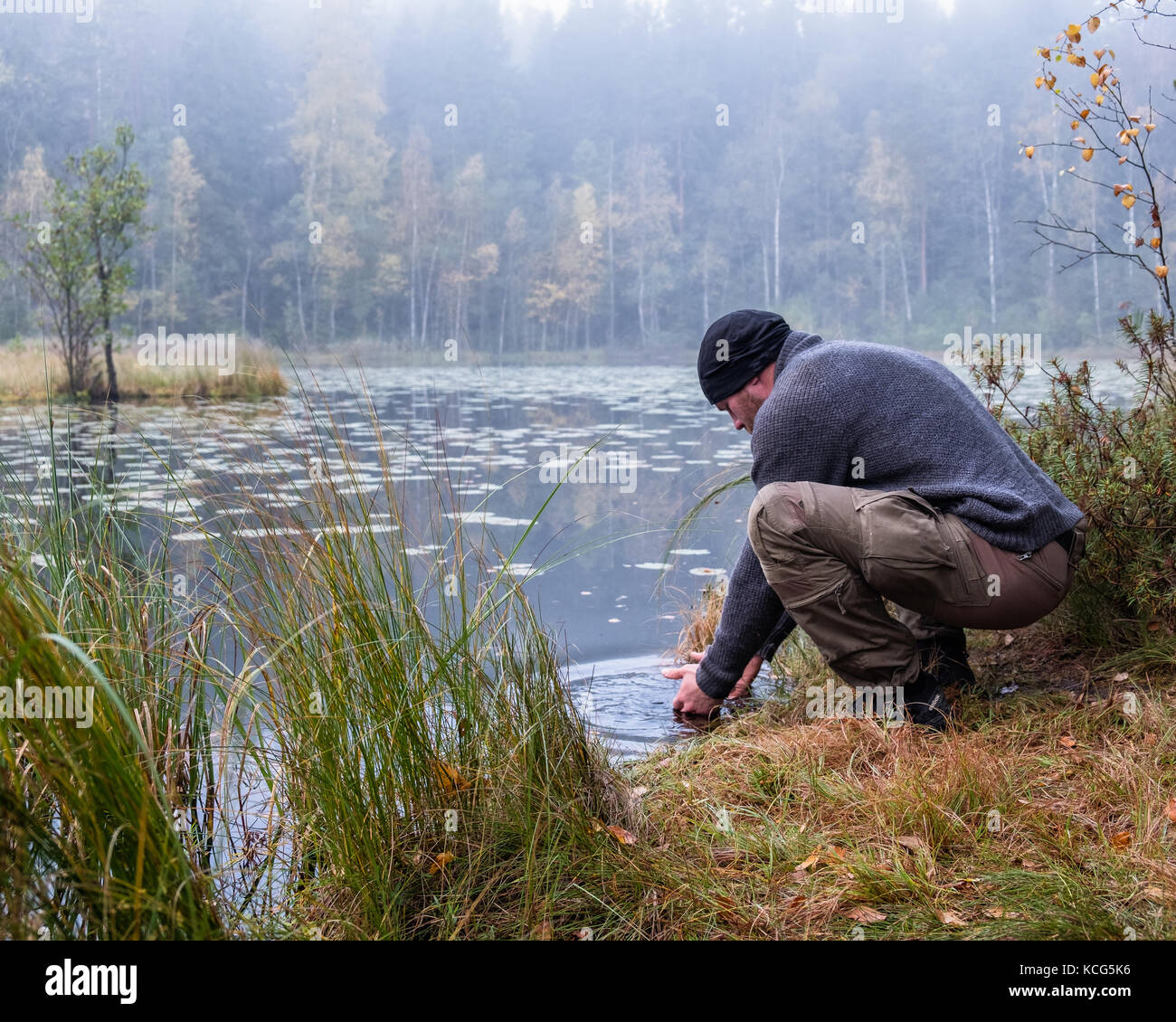 Lave-randonneur son visage au matin d'automne dans le parc national, la Finlande Banque D'Images
