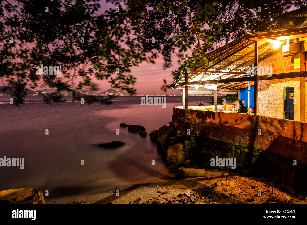 Restaurant rustique au bord de la mer à Ponta de Sambaqui ne le soir. Florianopolis, Santa Catarina, Brésil. Banque D'Images