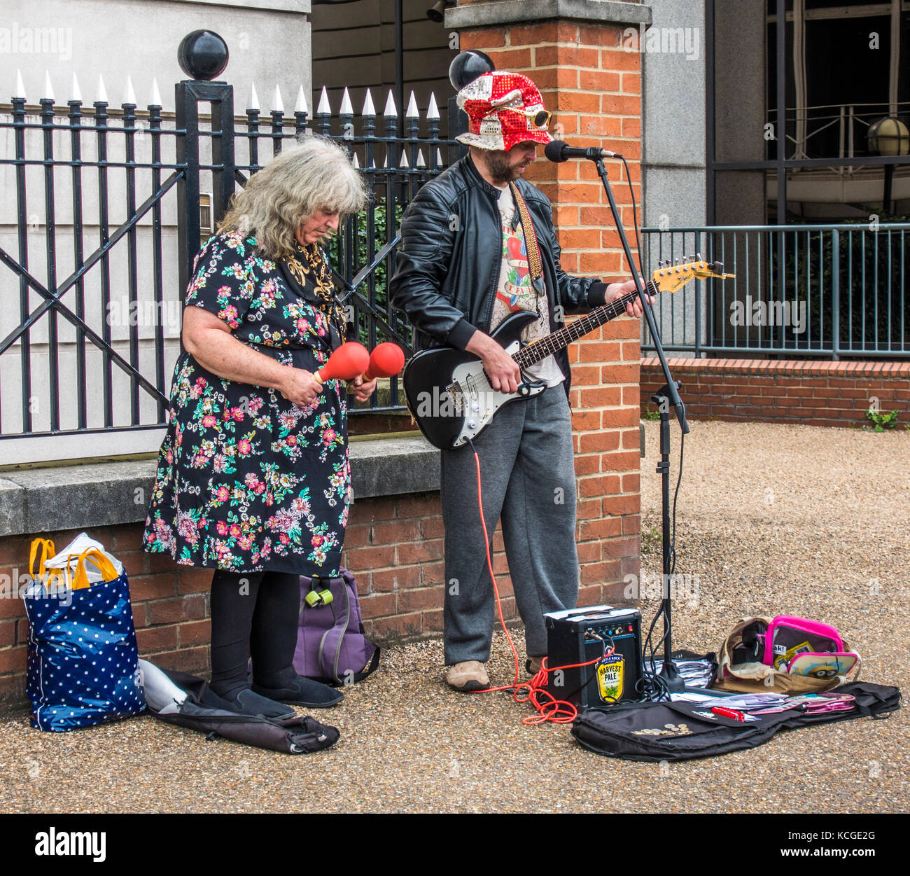 Busker excentrique / buskers : femme plus âgée et l'homme, jouer à la guitare électrique, avec microphone, l'amplificateur et les maracas. South Bank, Londres, Angleterre, Royaume-Uni. Banque D'Images