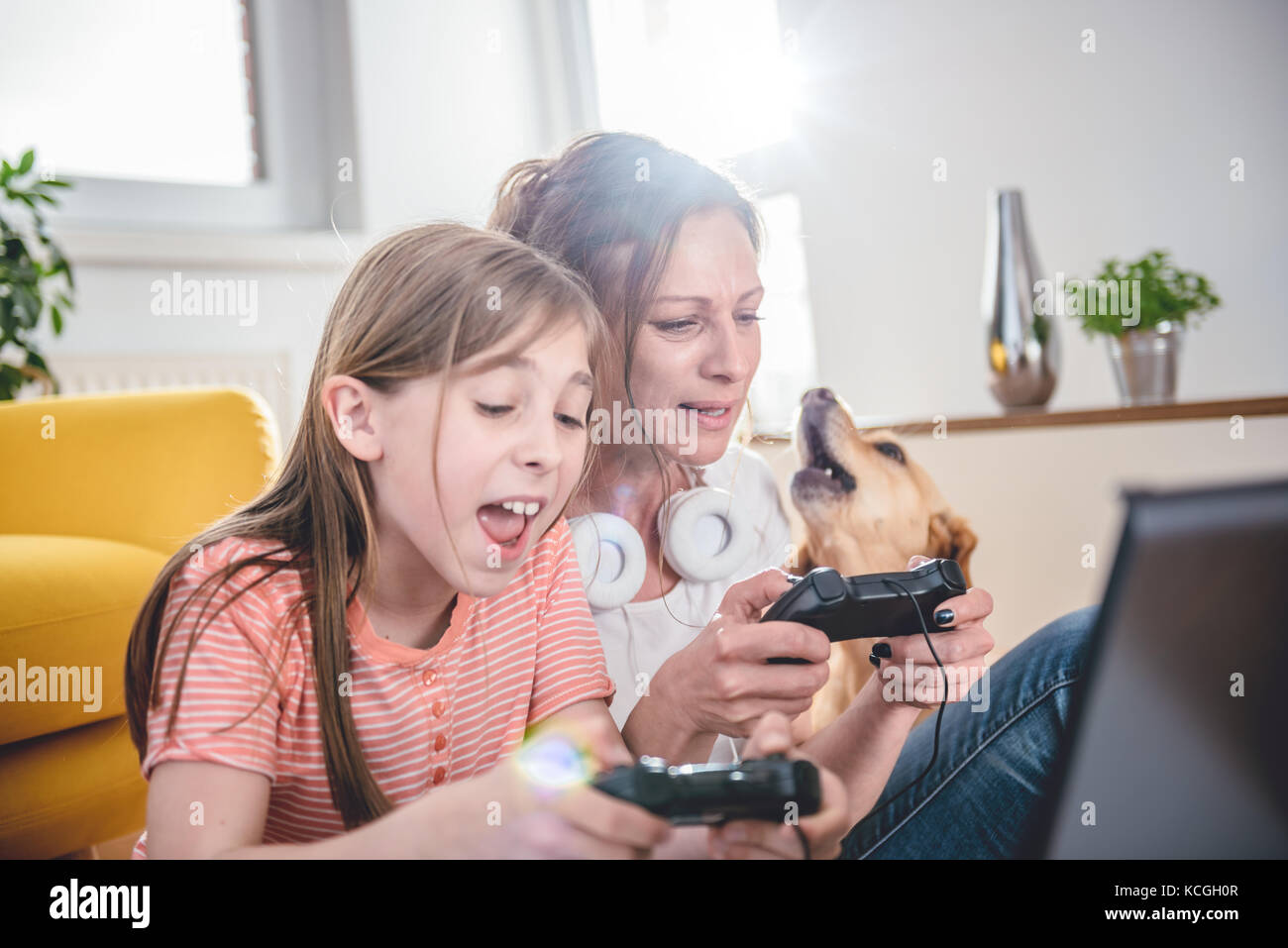 Mère et fille jouer à des jeux vidéo sur ordinateur portable à la maison Banque D'Images