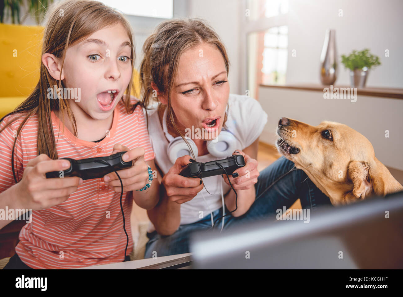 Mère et fille jouer à des jeux vidéo sur ordinateur portable à la maison Banque D'Images