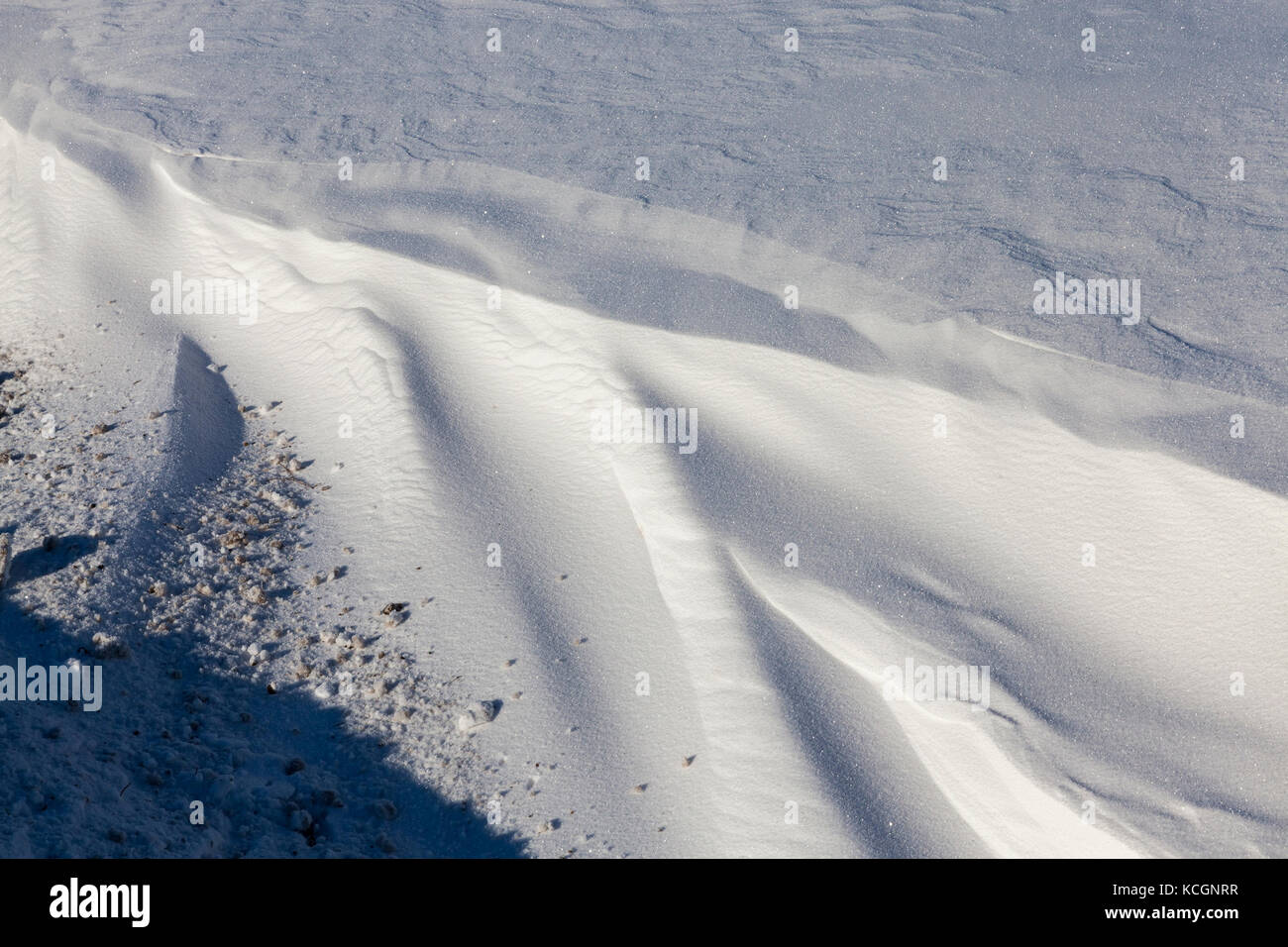 Des congères situées près de la route. sur la surface on peut voir la saleté de la route et des débris dans la profondeur de la neige. photo close up Banque D'Images