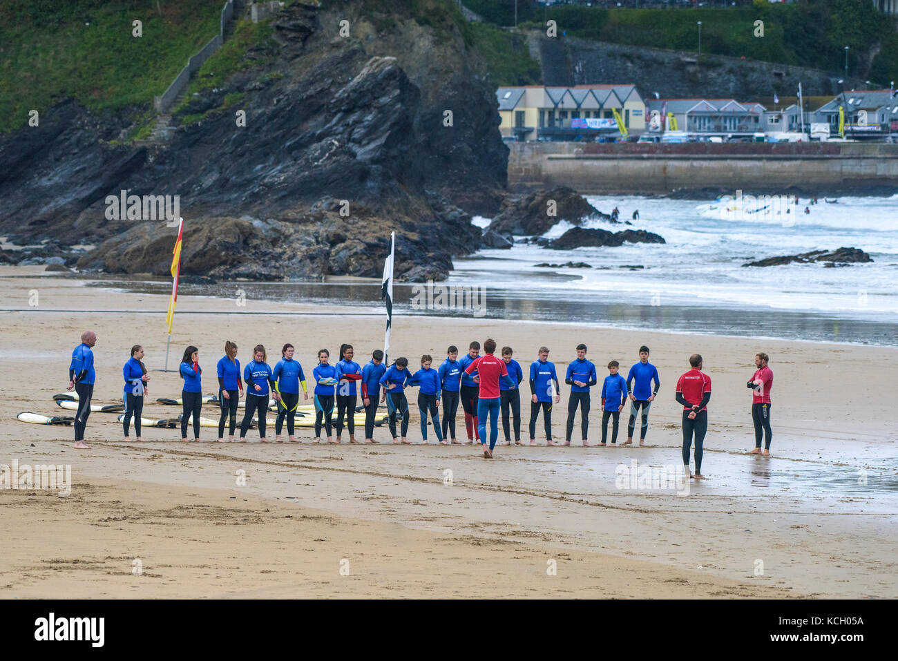 Le surf au Royaume-Uni. Les jeunes de l'écoute d'un instructeur de surf au début de leur leçon de surf. Banque D'Images