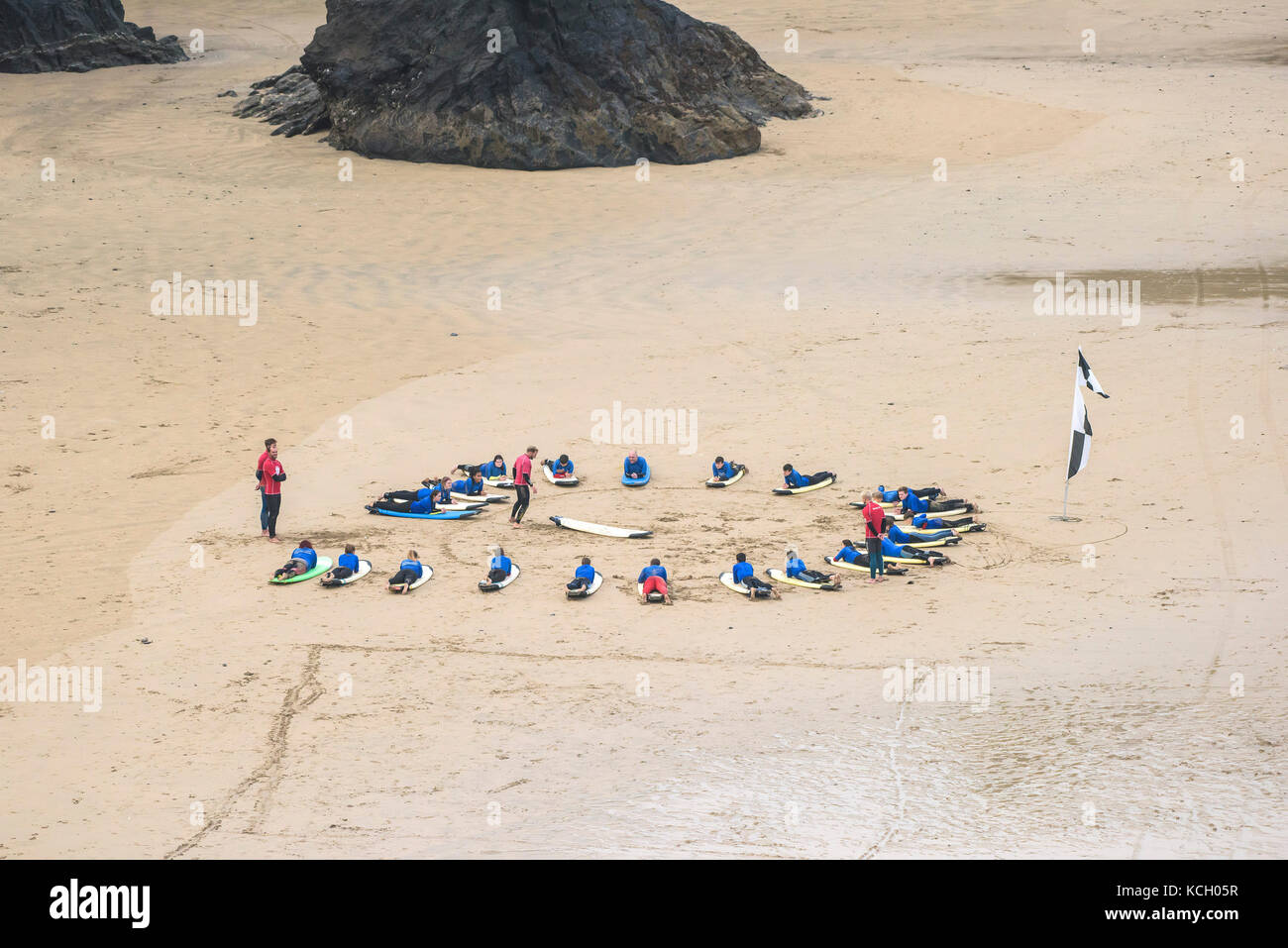 Le surf au Royaume-Uni. Les jeunes de l'écoute d'un instructeur de surf au début de leur leçon de surf à Newquay Cornwall. Banque D'Images
