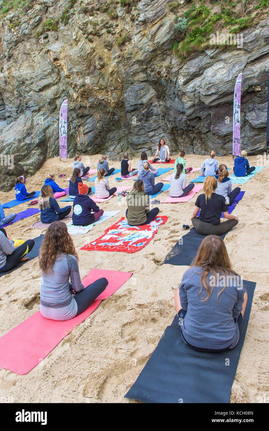 Un groupe de femmes pratiquant le yoga sur une plage - Surf Betty's Festival un festival tenu à Newquay et remise en forme l'autonomisation des femmes à travers le surf. Banque D'Images