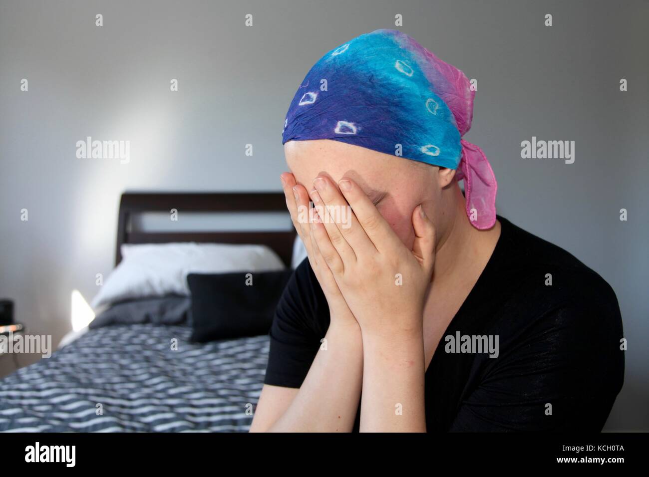 Les jeunes patients du cancer dans un foulard détient la tête dans les mains avec le stress Banque D'Images