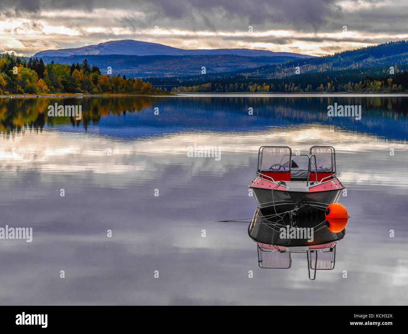 Le bateau en aluminium Buster se reflète dans le lac calme Åresjön, Åre, Jämtland, Suède.la bouée orange sécurise le bateau. Banque D'Images