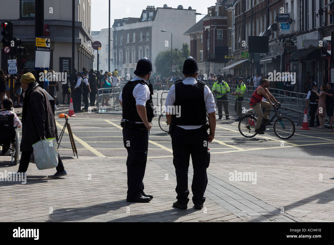 Policiers regardant des carnavaliers à Notting Hill Carnival, London, England, UK Banque D'Images