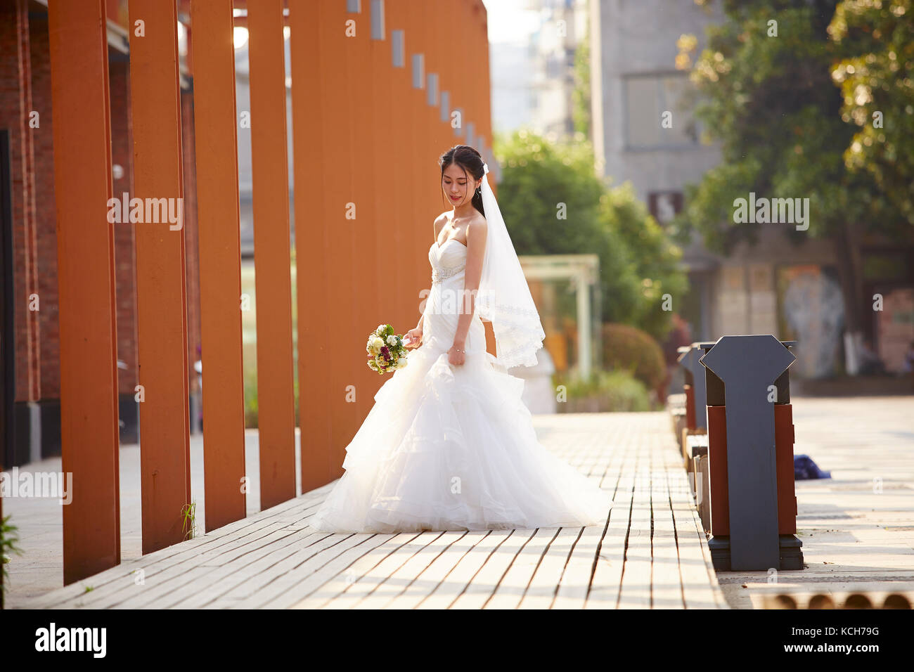 Portrait d'une jeune et belle Asian bride avec bouquet à la main. Banque D'Images