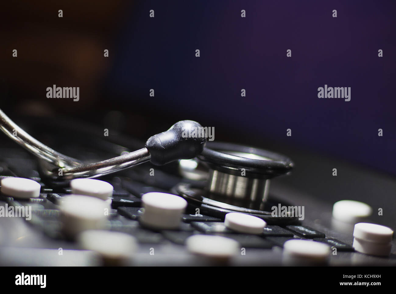 Ordinateur portable clavier avec tablette de médicaments et matériels médicaux stethoscope sur elle Banque D'Images