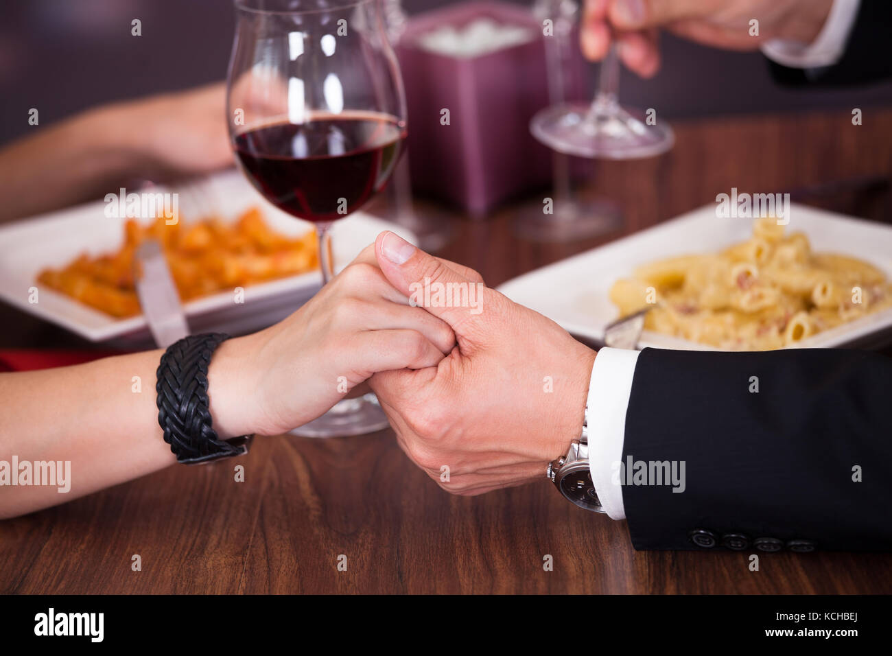 Couple romantique qui se tiennent la main à dîner dans un restaurant Banque D'Images