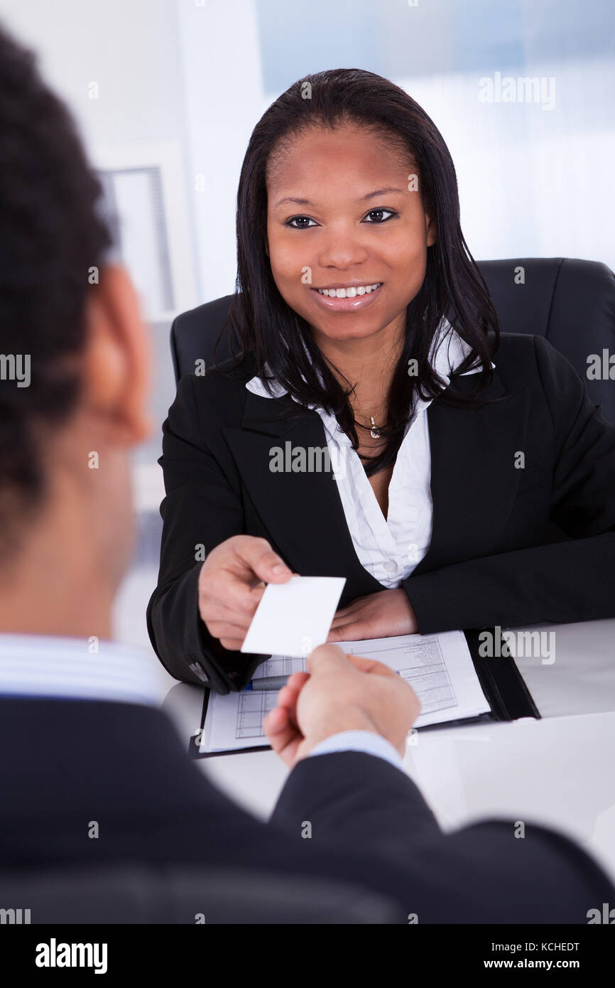 Portrait carte de visite offrant à man in office Banque D'Images