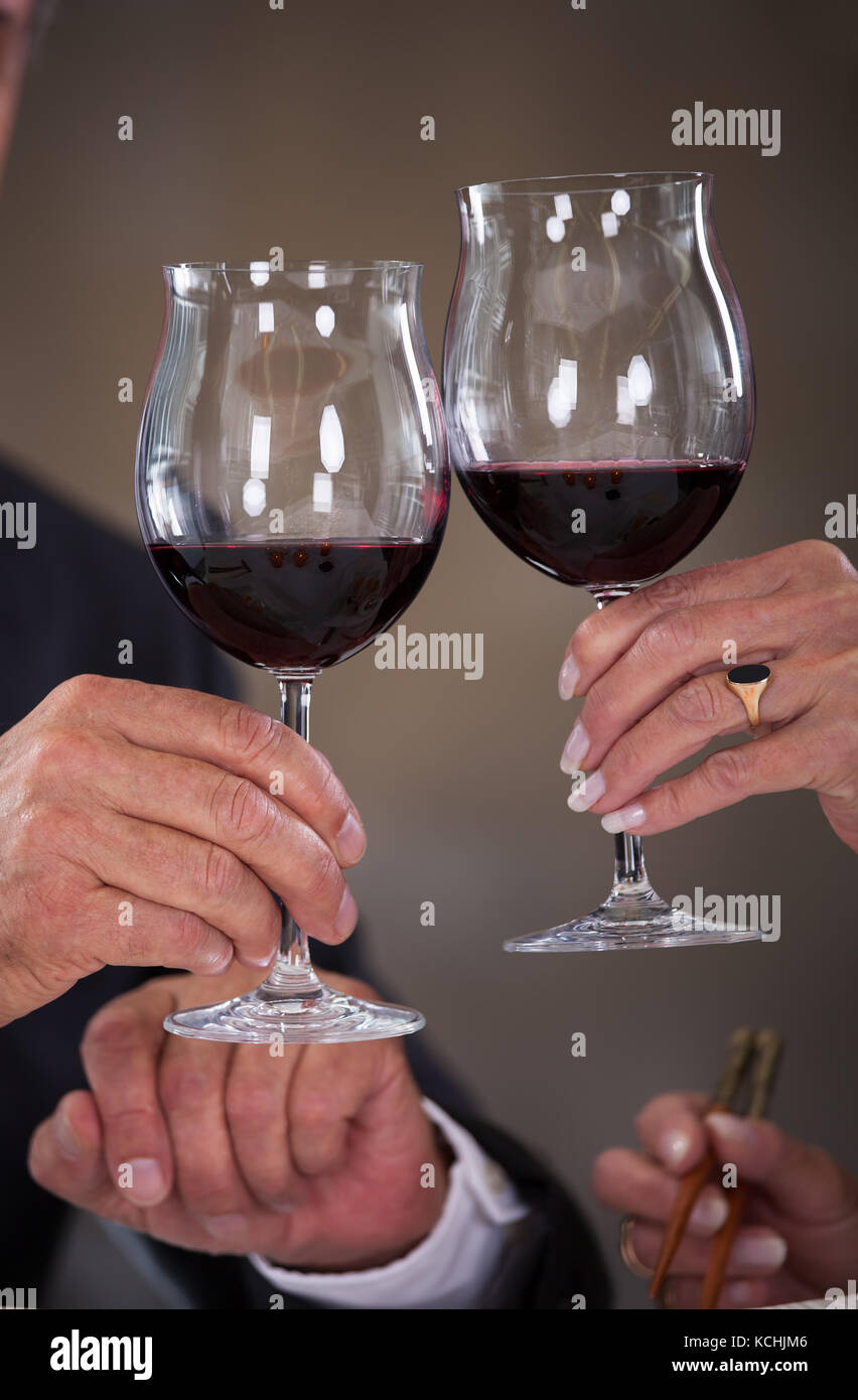 Mature couple toasting with wine dans un élégant restaurant Banque D'Images