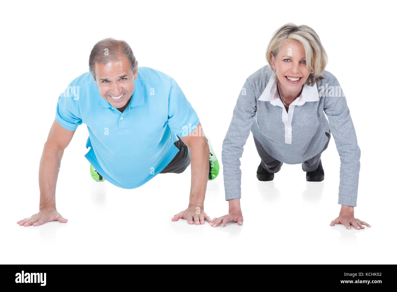 Mature couple doing push-ups isolé sur fond blanc Banque D'Images