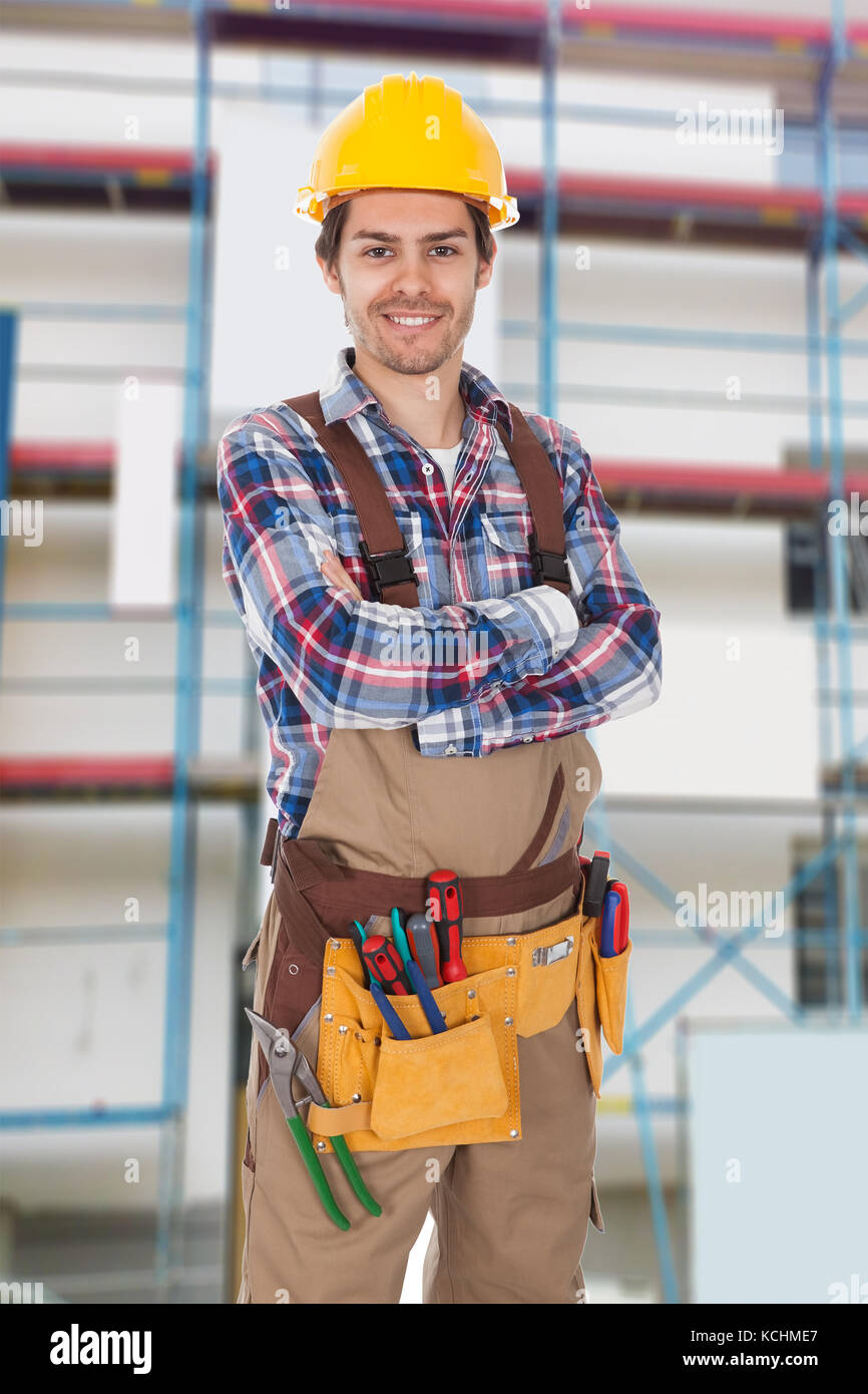 Travailleur Masculin Avec Ceinture À Outils Et Émetteur Radio Sur Le  Chantier De Construction Banque D'Images et Photos Libres De Droits. Image  184670692