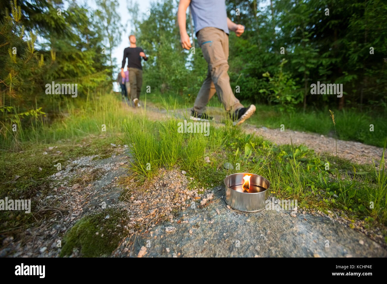 Hommes d'marche sur sentier éclairé par des bougies à réchaud en forêt durant la randonnée Banque D'Images