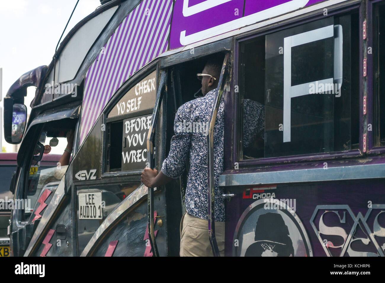 Conducteur de bus se trouve dans la porte à l'heure de pointe, Nairobi, Kenya Banque D'Images