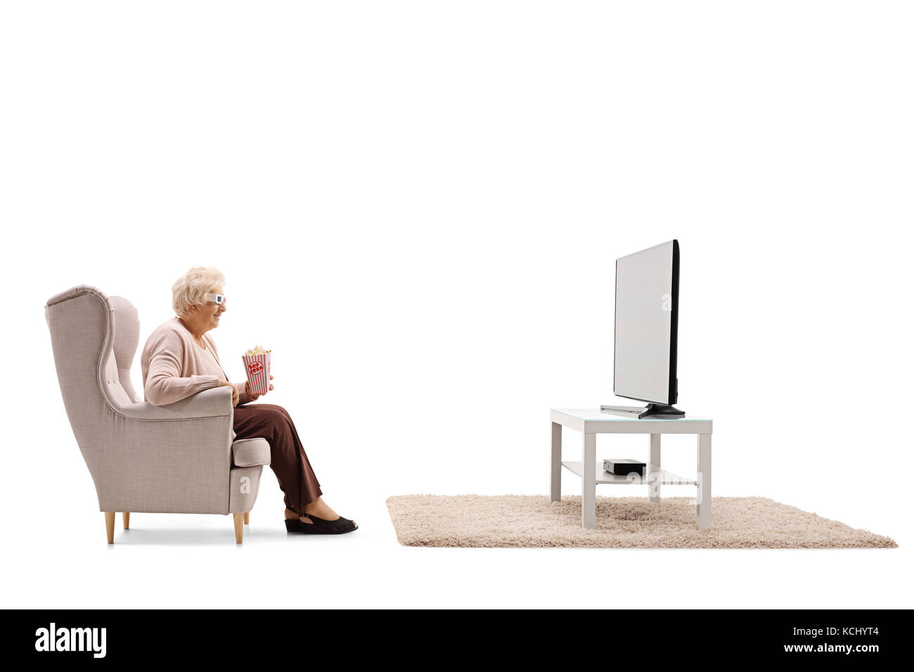 Femme âgée avec pop-corn et les lunettes 3d assis dans un fauteuil et regarder la télévision isolé sur fond blanc Banque D'Images
