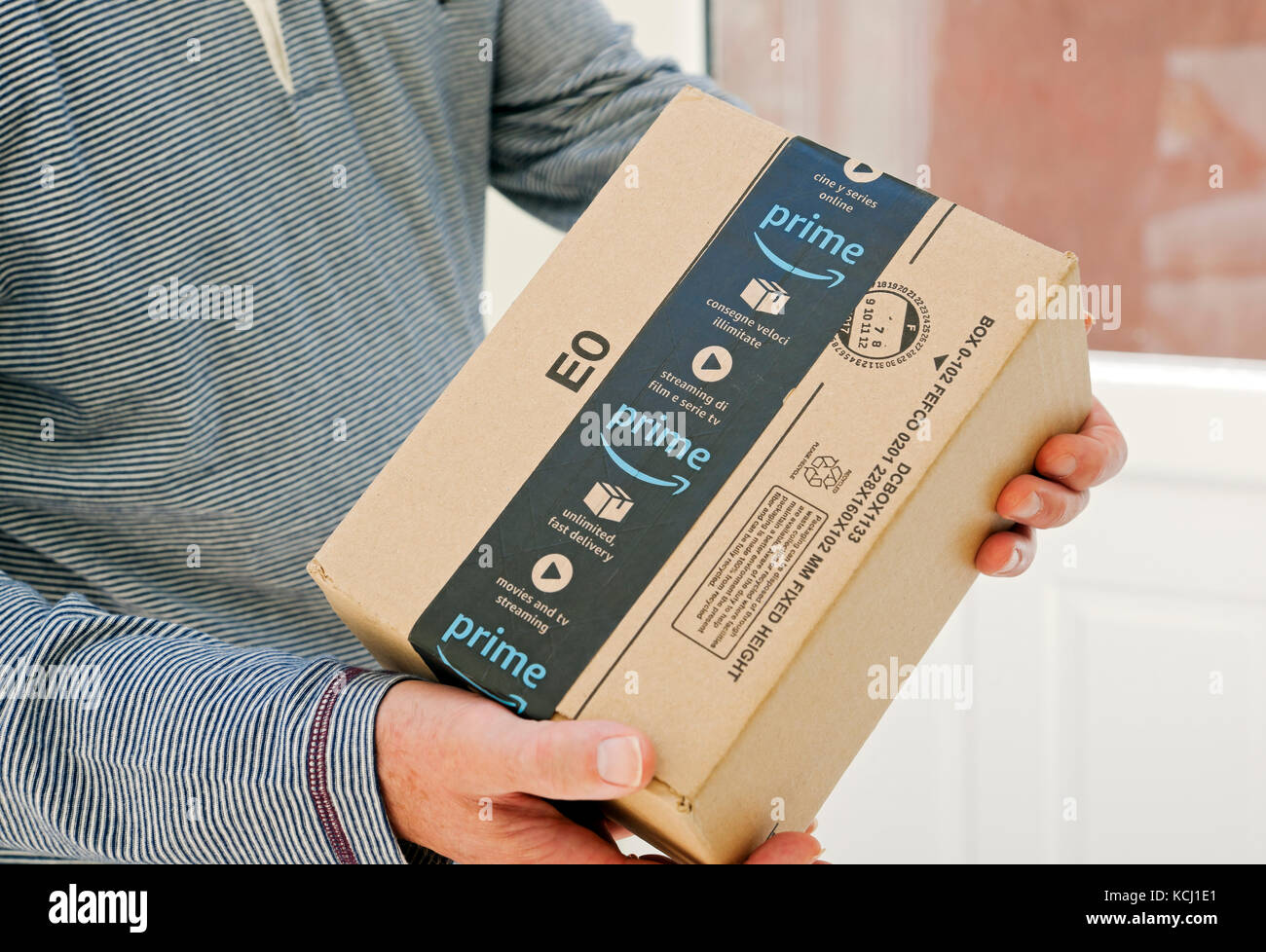 Gros plan de la personne homme holding livrant une Amazon premier boîte colis colis home Internet shopping livraison Angleterre Royaume-Uni Grande-Bretagne Banque D'Images
