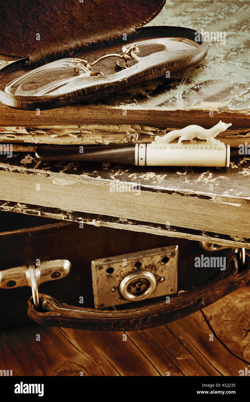 Valise en cuir avec de vieux livres, d'ivoire porte-cigarette et pince-nez  dans une boîte de métal sur un fond de bois effet rétro Photo Stock - Alamy