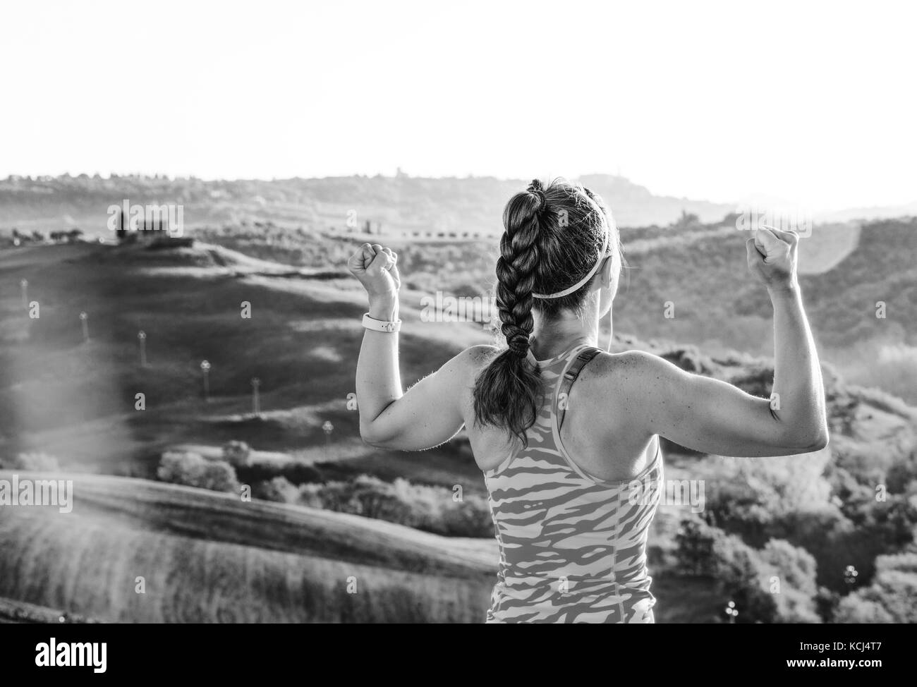 Remise en forme et une vue magique de la toscane. vu de dos fit woman jogger en vêtements de sport à l'avant de paysages de la toscane se réjouir Banque D'Images