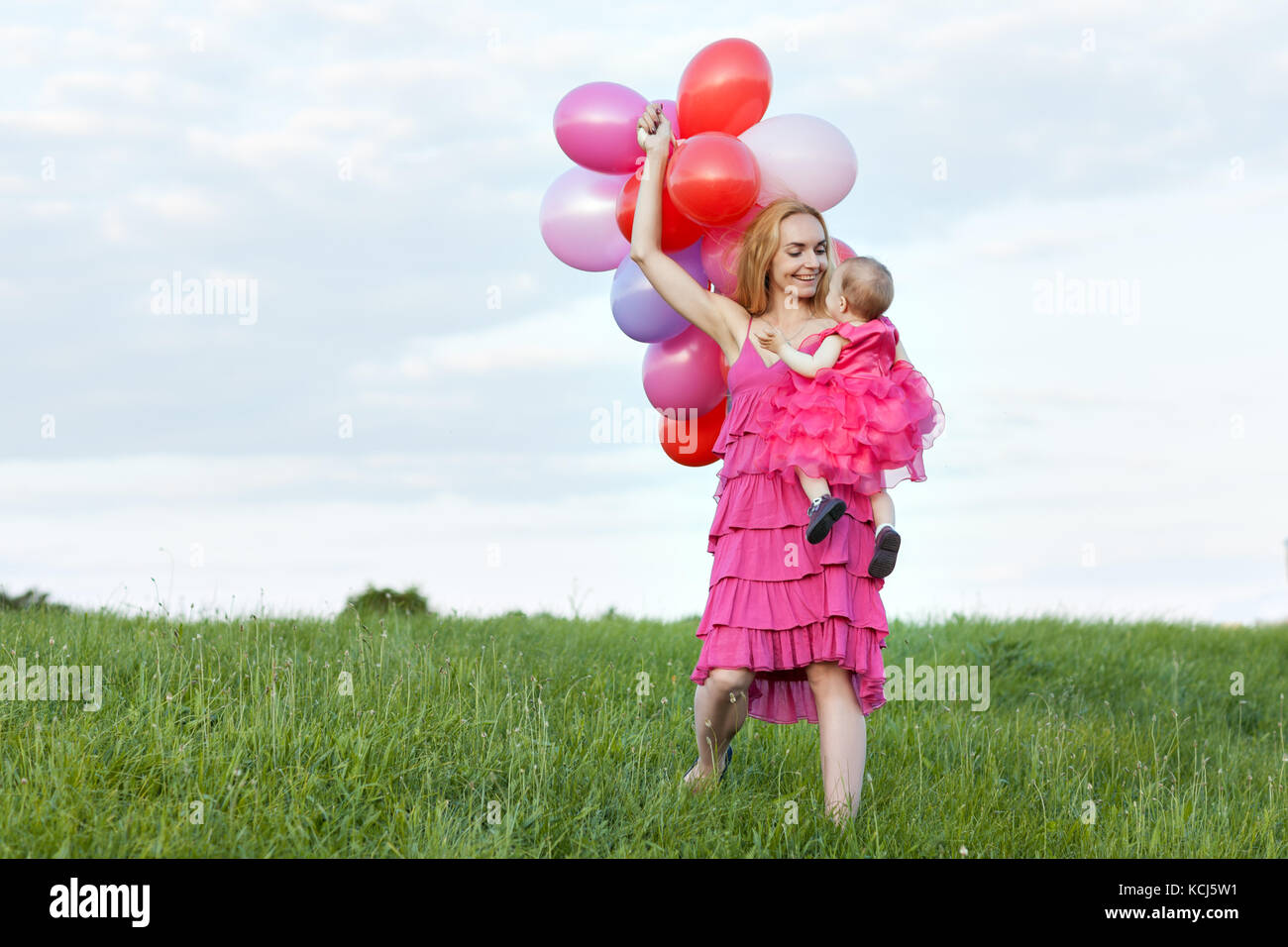 Maman est titulaire d'une fille et de ballons dans ses mains. maman et sa fille regarder les uns les autres Banque D'Images